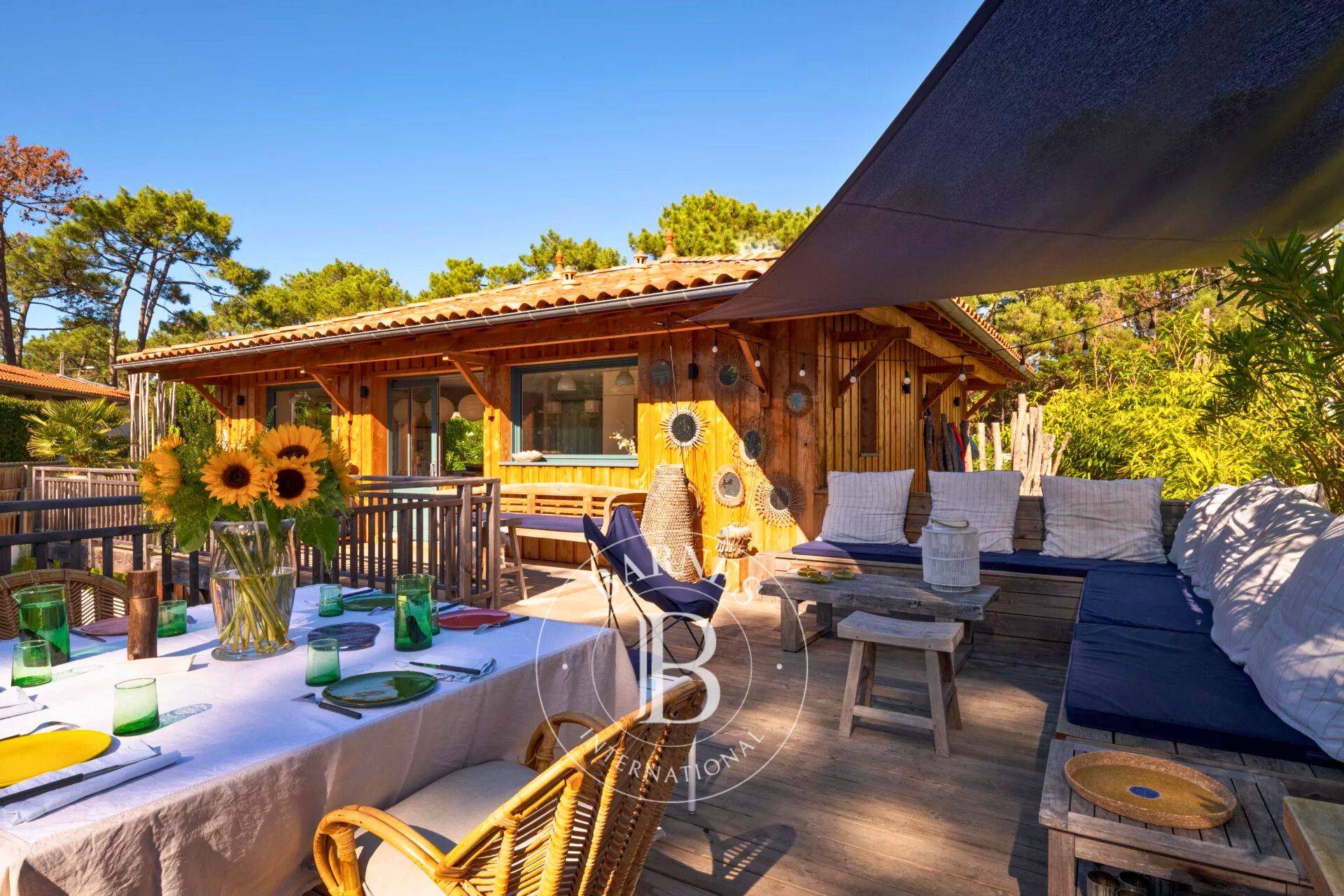 Terrasse en bois avec salon de jardin et espace repas - Barnes Bassin d’Arcachon.