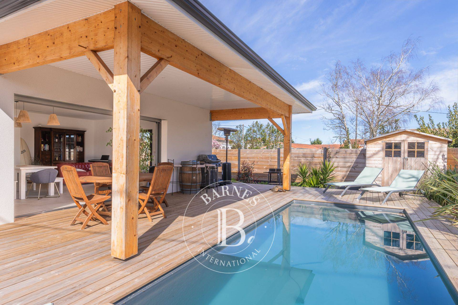 Piscine et terrasse en bois dans un jardin paysager