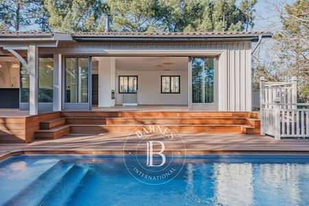 Salon lumineux avec cheminée et grandes baies vitrées, villa à Pyla-sur-Mer
