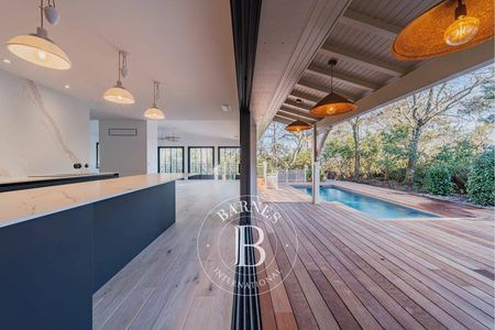 Cuisine équipée ouverte sur terrasse semi-couverte, villa contemporaine