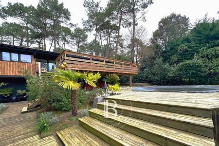 Pièce de vie lumineuse avec baies vitrées et terrasse en bois - Barnes Bassin d’Arcachon.